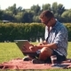 Young Smiling Man Working On Laptop In Sunny Park - VideoHive Item for Sale