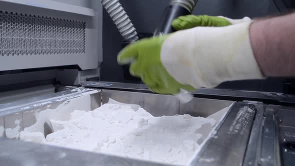 A Man Working with a Working Vacuum Cleaner to Clean White Powder of Polyamide alt