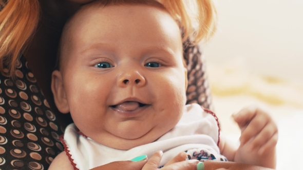 Mother Sitting With Adorable Baby On Hands. Motherhood. Baby Has Blue Eyes alt