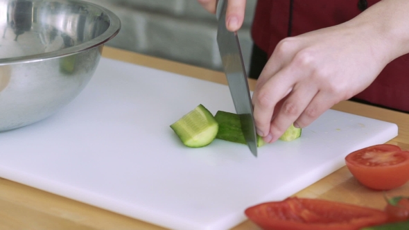 Hands Slicing Cucumber, Tomatoes And Putting Into Bowl alt
