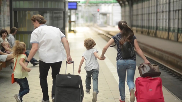 Young Family Of Two Spouses, Son And Daughter, Running In The Railway Station, Father Holding alt