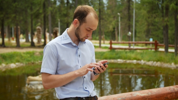 Man Using Mobile Smart Phone in Park