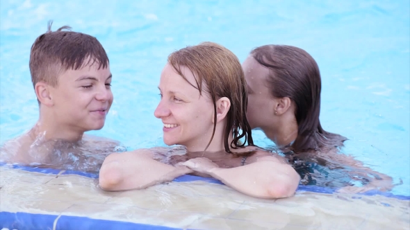 Happy Family Enjoying In Pool