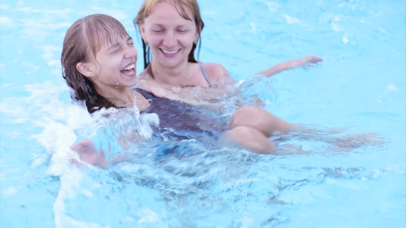 Happy Family Enjoying In Pool