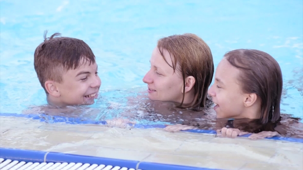 Happy Family Enjoying In Pool