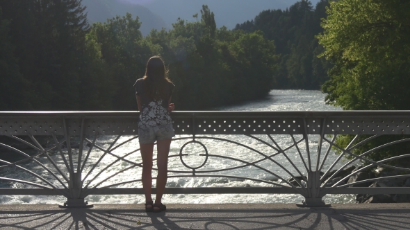 Girl Stands On The Bridge Over The River