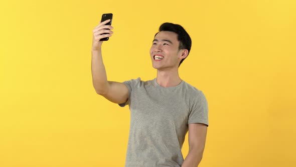 Happy Asian man making video call on smartphone
