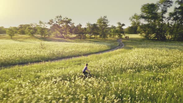 Aerial of Young Woman Riding Bicycle at Dirt Road alt