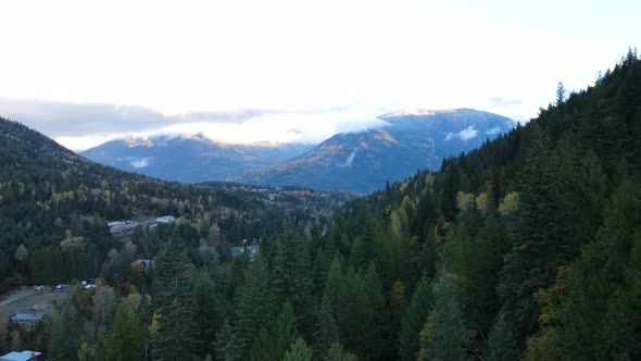 4k aerial footage of vast and colourful forest covered mountains in Nelson, Canada. Large mountain r alt