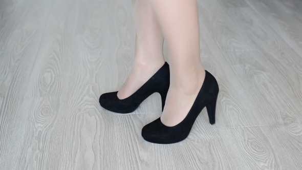 Woman Takes Off Down a Black High-heeled Shoes