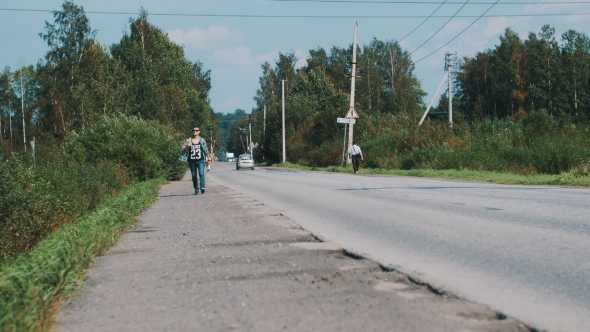Boy In Sunglasses Walking Along Road With Map. Travel. Hitchhiking. Thumb Up alt