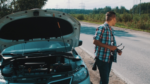 Boy Sit On Broken Car At Road. Hitchhiking. Waiting For Help. Thumb Up. Summer alt
