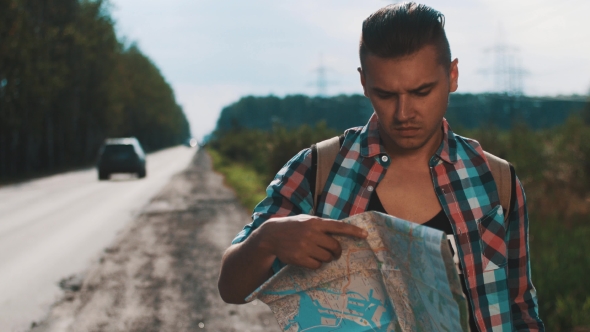 Boy With Backpack Looking In Map At Roadside. Hang Up Phone. Summer Sunny Day alt