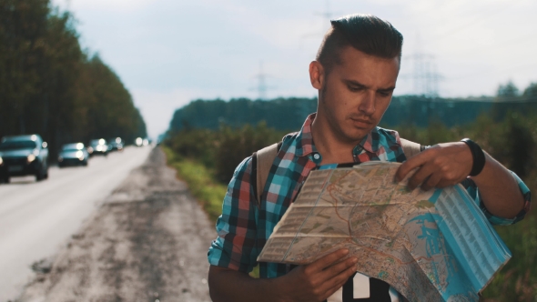 Boy With Backpack Looking In Map At Roadside. Cars. Summer Day. Talk On Phone alt