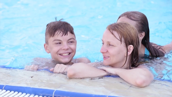 Happy Family Enjoying In Pool