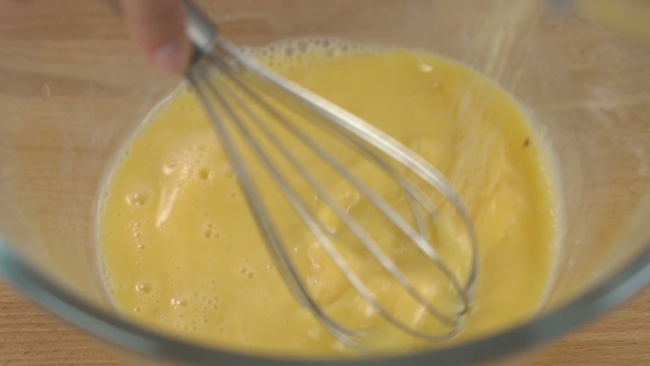 Beaten Eggs With Whisks In Bowl. Sugar Being Pouring Into Bowl.