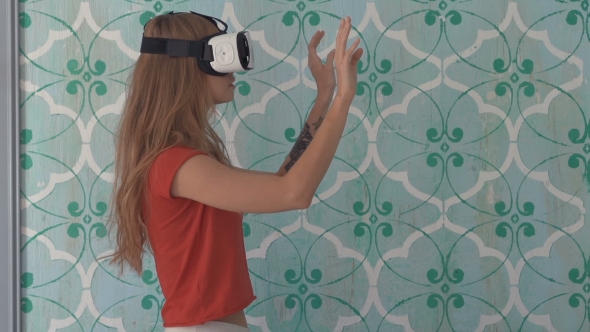 Young Woman With VR Device Touching Something Invisible