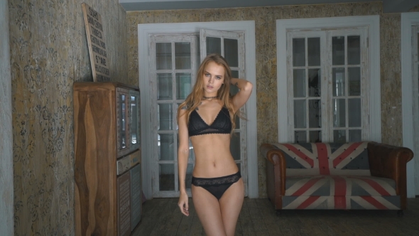 Young Woman Wearing a Black Lingerie Posing At Loft Home