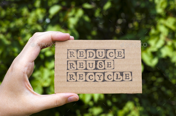 Woman hand holding cardboard card with words Reduce Reuse Recycle