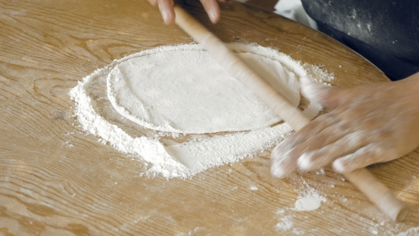 Rolling The Pastry Dough On a Flat Wooden Surface