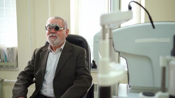 Ophthalmologist Diagnoses Elderly Man's Vision and Makes Selection of Lenses alt