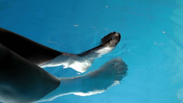 Woman Put Feet In The Water In Order To Relax
