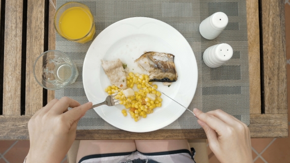 Lady Is Using Utensils To Cut Meal In Small Bites
