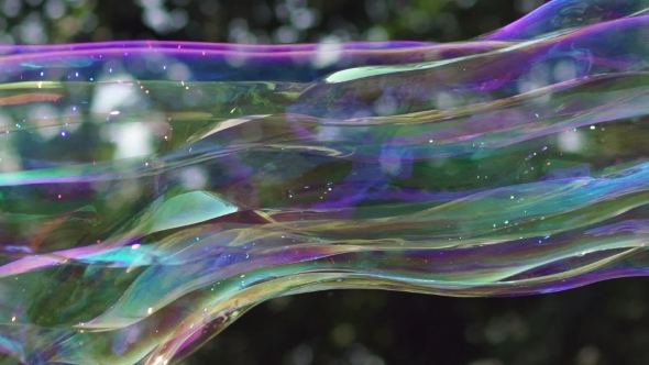 View Of Colorful Big Long Soap Bubble Is Flying In The Park