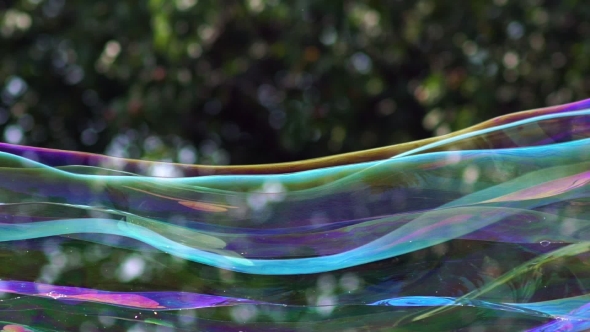  View Of Colorful Big Long Soap Bubble Is Flying In The Park