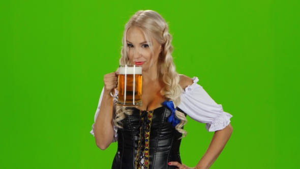 Women In Traditional Bavarian Tracht Drinking Beer And Showing Thumbs Up. Green Screen alt