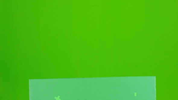 Bavarian Girl Looks Out From Behind The Green Board And Winking. Green Screen alt