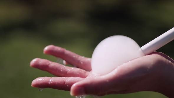 Lather And Tubing To Create Bubbles In The Palm Of Woman’s Hand