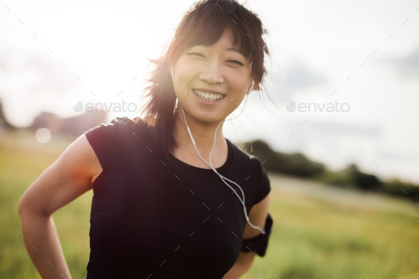 Happy female running standing outdoors and smiling - Stock Photo - Images