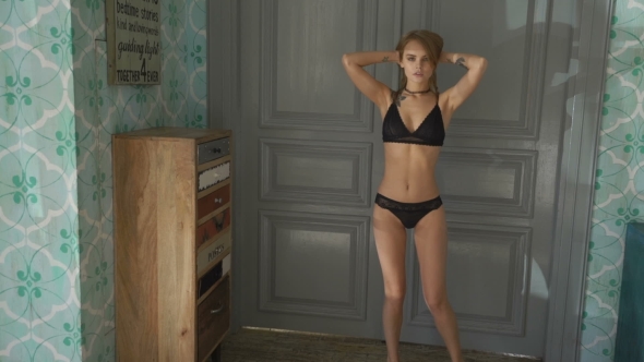 Sexy And Attractive Girl Indoor Wearing a Black Lingerie, Posing Near Door