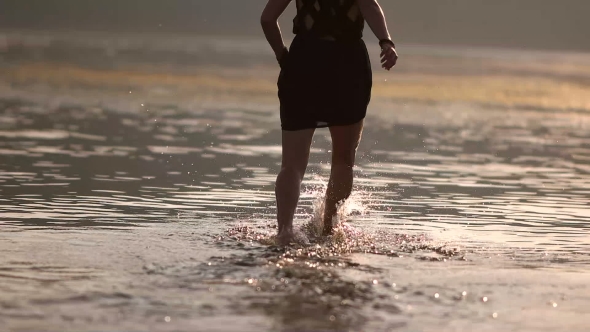 Girl Runs Along The Beach Knees In Water
