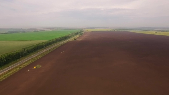 Aerial Panorama Of Agricultural Fields With Roads, Lake, Forest And Beautiful Cloudy Sky On Horizon