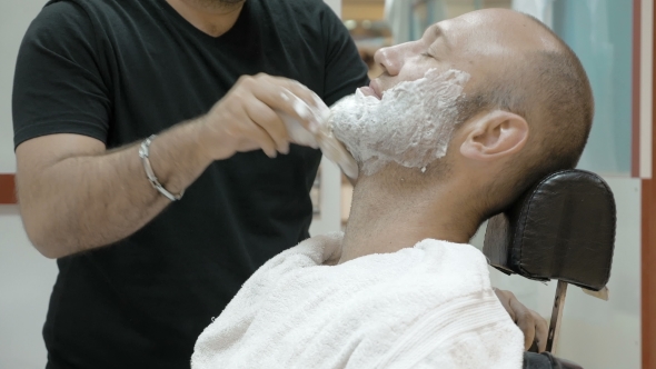 A Man Is Sitting At a Barber's Shop To Get Groomed