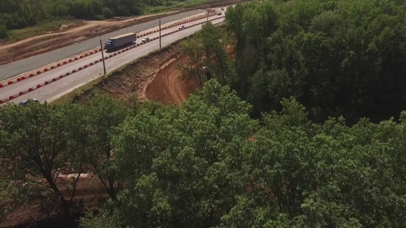Drone Flying From Trees And Showing How Crane Laying Pipes For Road Construction