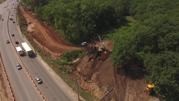 Aerial Shot Of Road Construction, Construction Machinery Standing In Forest