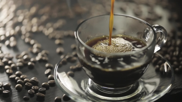 Pouring Hot Black Coffee Into Transparent Cup