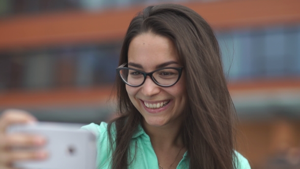 The Girl With a Beautiful Smile Is Photographed On The Phone.