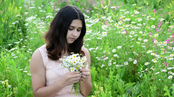 Beautiful Girl With Bouquet Of Daisies In a Meadow