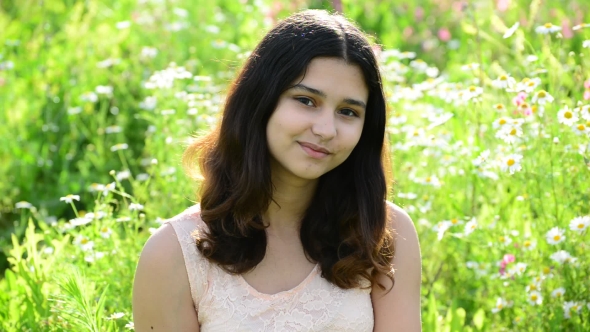 Young Girl Shyly Looking at Camera Outdoors