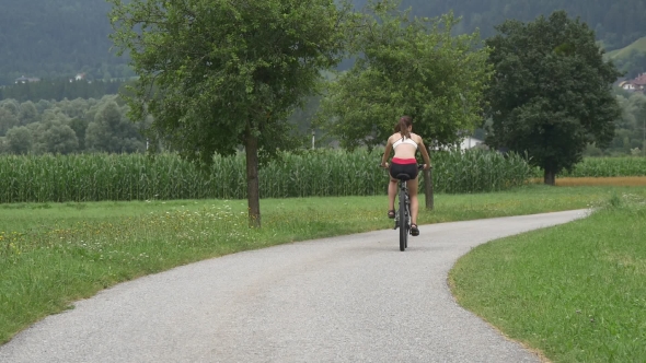 Young Girl Riding Cycles On Rural Road