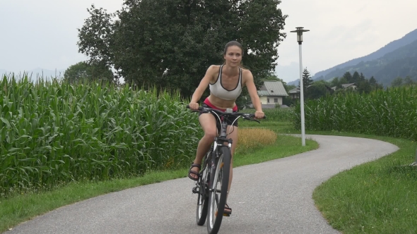 Fit Woman Cycles Along The Bike Trail