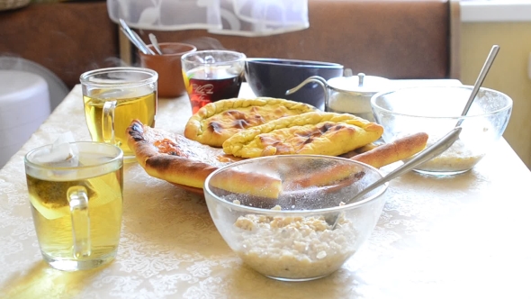 Healthy Breakfast With Tea, Oatmeal And Pies On a Table