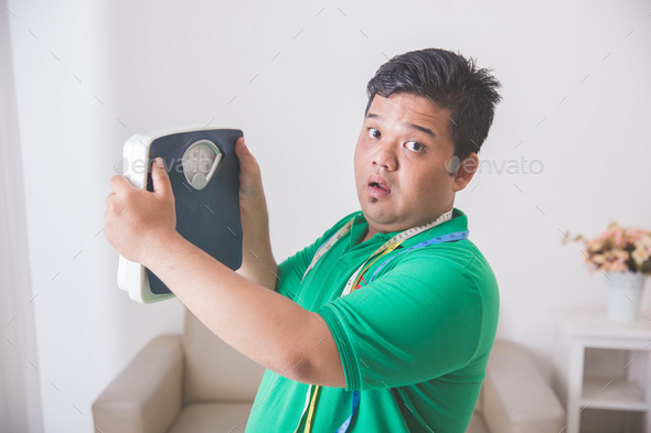 shocked obese man while looking at a weight scale