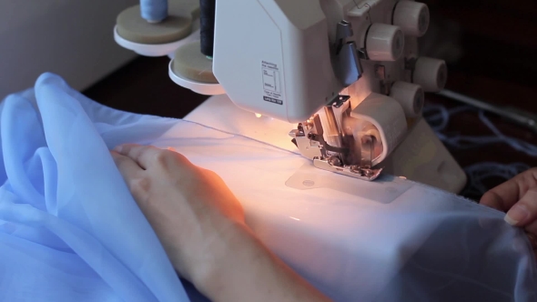 Woman Treated Tissue Using Overlock. Women's Hands. Quickly Sew .