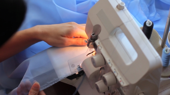 Woman Corrects And Processes The Fabric On The Overlock. Diligent, Hard Work. . alt