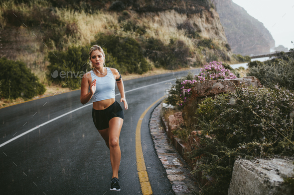 Fitness woman running on countryside highway - Stock Photo - Images
